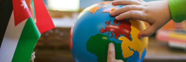 Children touching globe