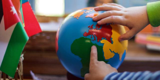 Children touching globe